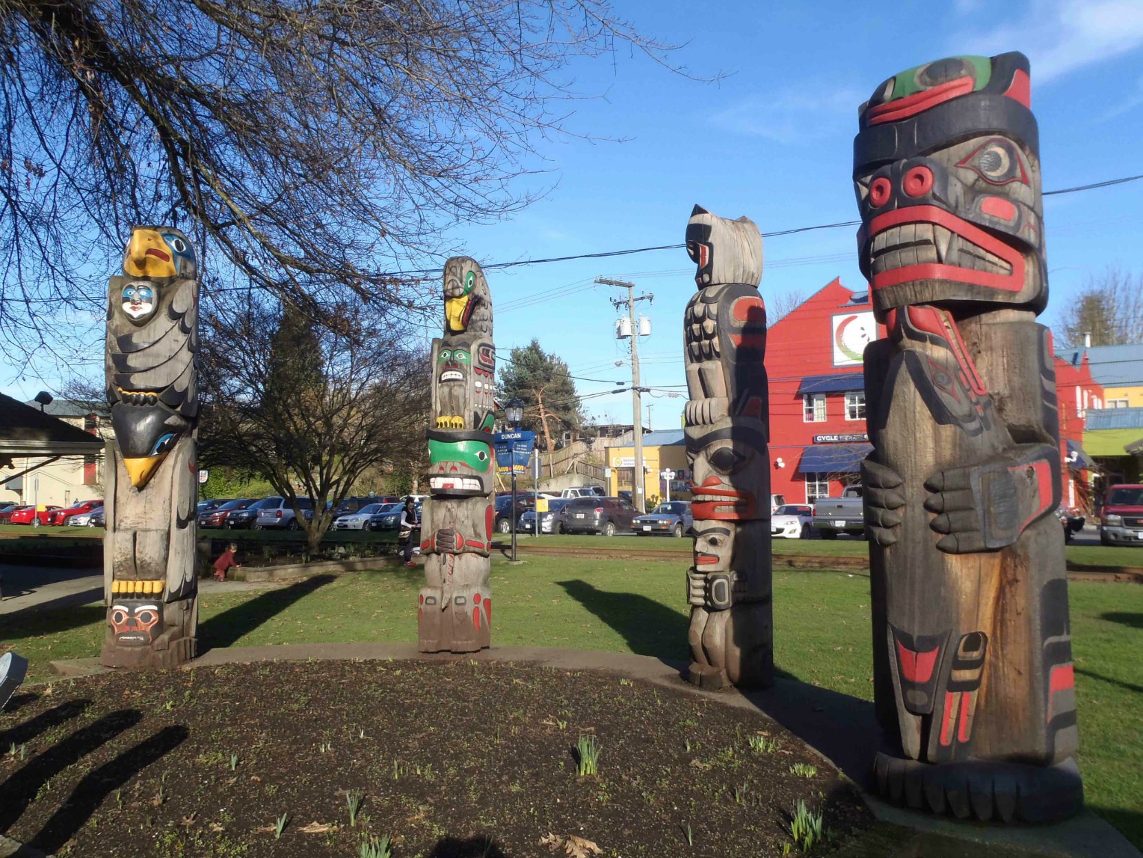 Four totem poles displayed in Charles Hoey Park on Canada Avenue. Left to right: Transformation In Life, The Friendship Pole, Owl Pole and Kwagu'l Bear Holding A Seal