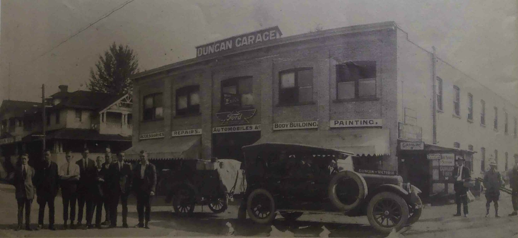 Duncan Garage, circa 1921. The car in the photo is the Duncan to Victoria bus service operated by Duncan Garage. Note the trailer behind the car.
