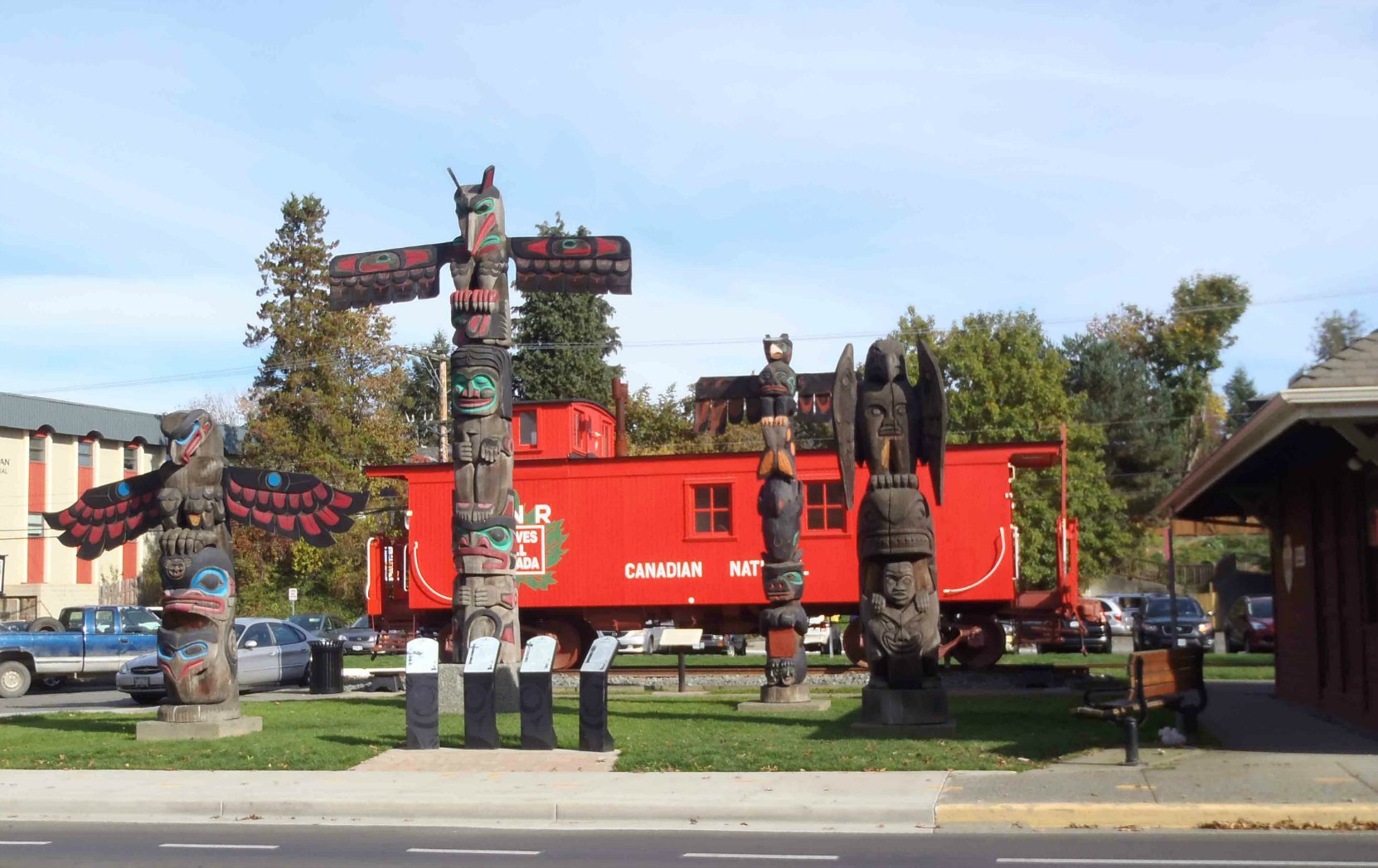 Canada Avenue totem pole display. Left to right: The Feast, Raven's Gift, Pole of Wealth and Transformation